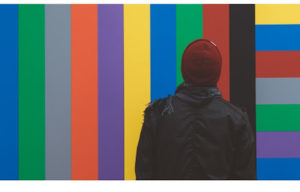 man with bonnet in front of colored rainbow lines
