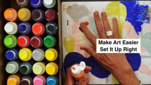 Row of colorful paint bottles beside a painting in progress; a hand drips orange paint onto the canvas with a bold “Make Art Easier Set It Up Right” overlay.