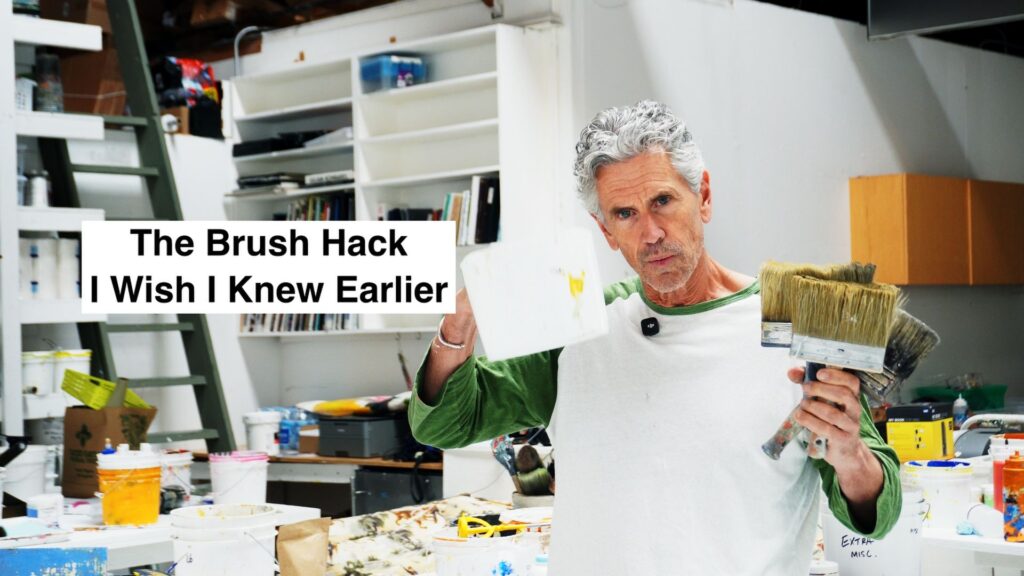 A painter in a cluttered studio holds brushes; overlay text reads 'The Brush Hack I Wish I Knew Earlier'.